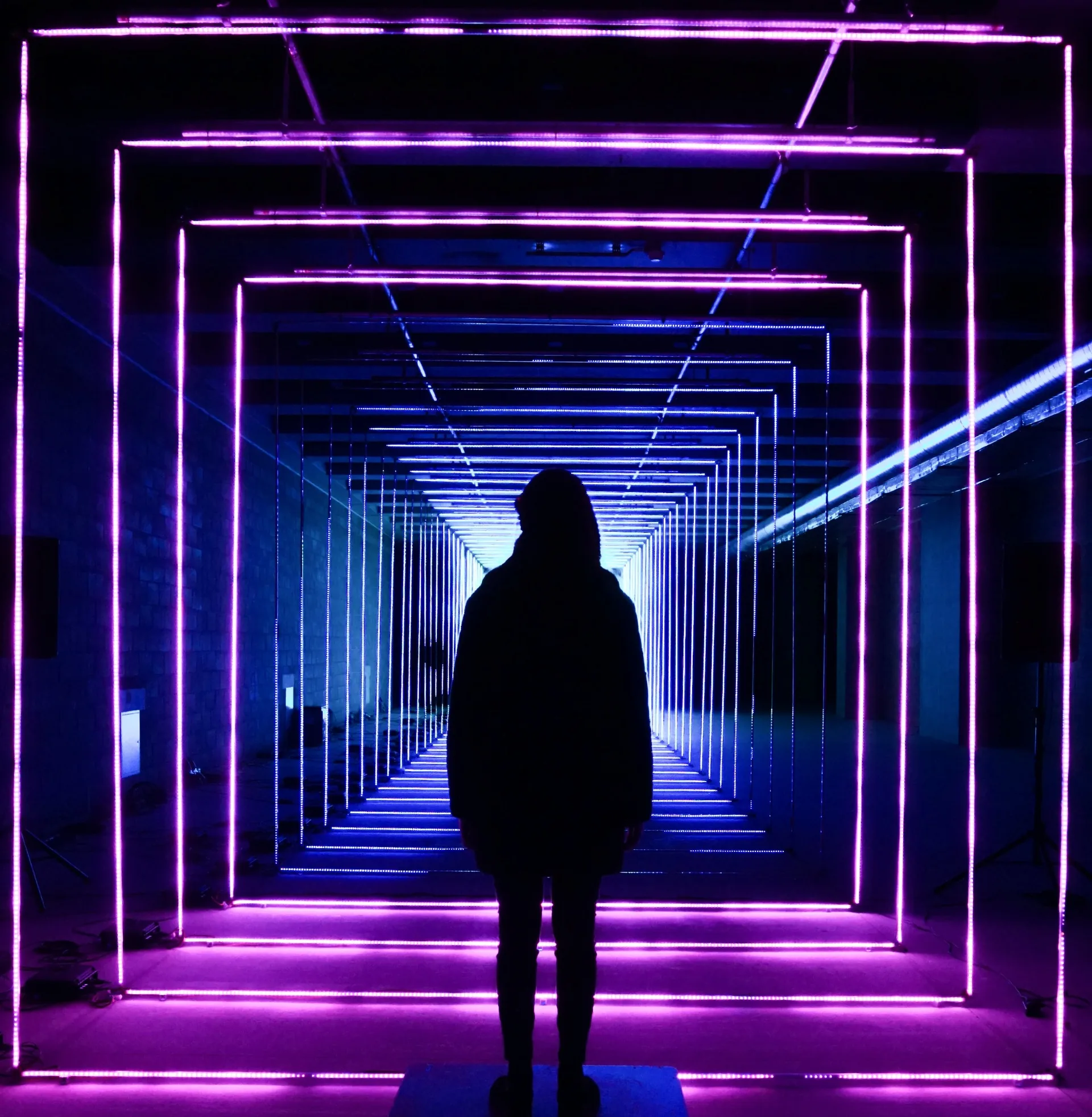 Silhouette standing in a neon corridor
